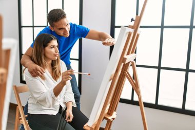 Öğrenci ve öğretmen resim yaparken gülümsüyor..