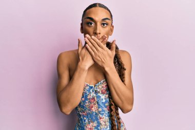 Makyaj yapan, uzun saçlı, zarif korse giyen İspanyol bir adam ağzını yanlışlıkla elleriyle kapatmış. gizli kavram. 