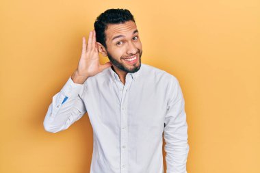 Sakallı, iş gömleği giyen, ağzı kulaklarında bir dedikodu duyan İspanyol bir adam. Sağırlık kavramı. 