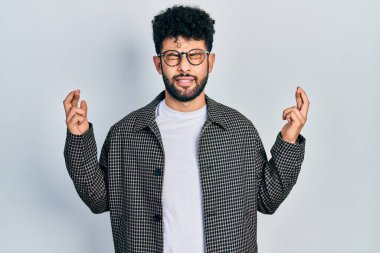 Sakallı, gözlüklü genç bir Arap. Umut ve gözlerin kapalı gülümseyerek el sallıyor. Şans ve batıl inançlar. 