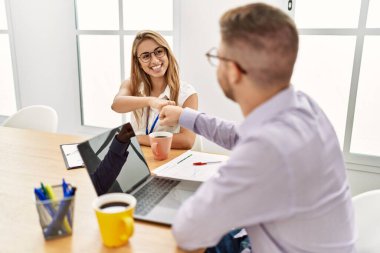 İki iş adamı ofiste el sıkışarak mutlu bir kutlama yapıyor..