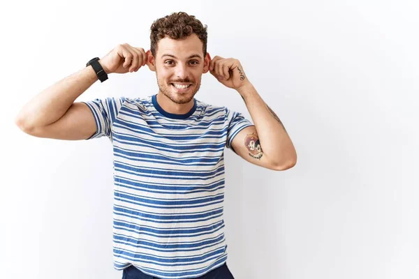 Guapo Joven Pie Sobre Fondo Aislado Sonriendo Tirando Las Orejas — Foto de Stock