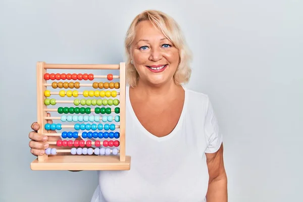 Medelålders Blond Kvinna Som Håller Traditionell Abacus Ser Positiv Och — Stockfoto