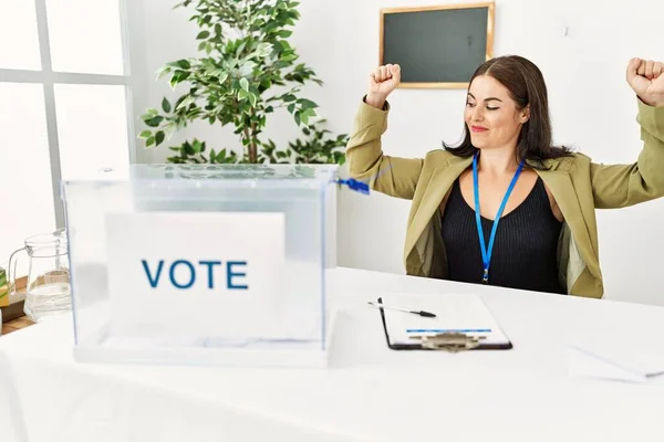 Молодая Брюнетка Сидящая Избирательным Столом Избирательным Бюллетенем Показывает Мускулы Рук — стоковое фото