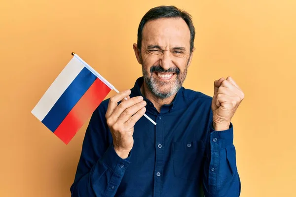 Homem Hispânico Meia Idade Segurando Bandeira Rússia Gritando Orgulhoso Celebrando — Fotografia de Stock
