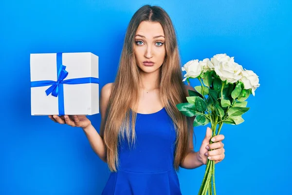 Joven Chica Rubia Sosteniendo Regalo Aniversario Ramo Flores Escéptico Nervioso — Foto de Stock