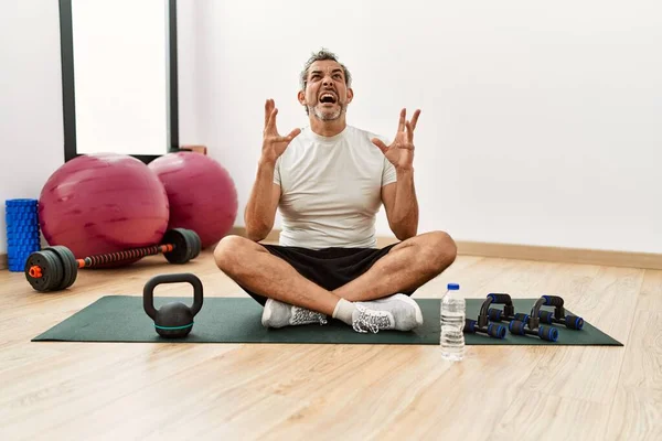 Mellanåldern Hispanic Man Sitter Träningsmatta Gymmet Galen Och Galen Skrika — Stockfoto