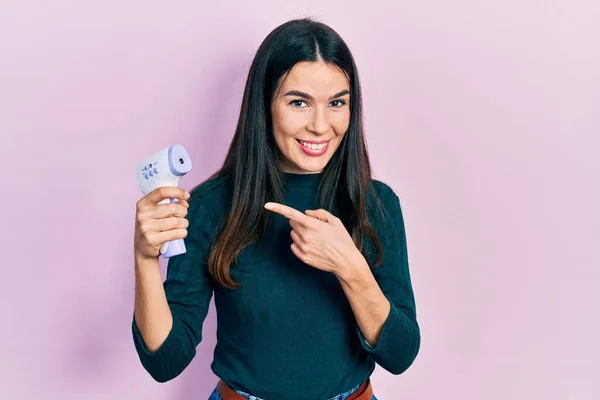 Ung Brunett Kvinna Håller Termometer Ler Glad Pekar Med Hand — Stockfoto