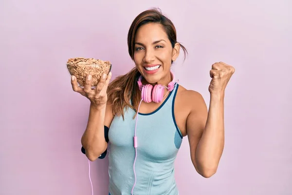 Young Latin Woman Wearing Gym Clothes Using Headphones Holding Cornflakes — Stock Photo, Image