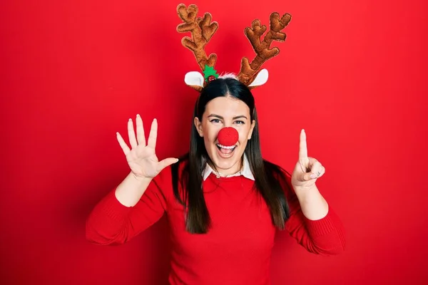 Jovem Hispânica Usando Chapéu Natal Veado Nariz Vermelho Mostrando Apontando — Fotografia de Stock