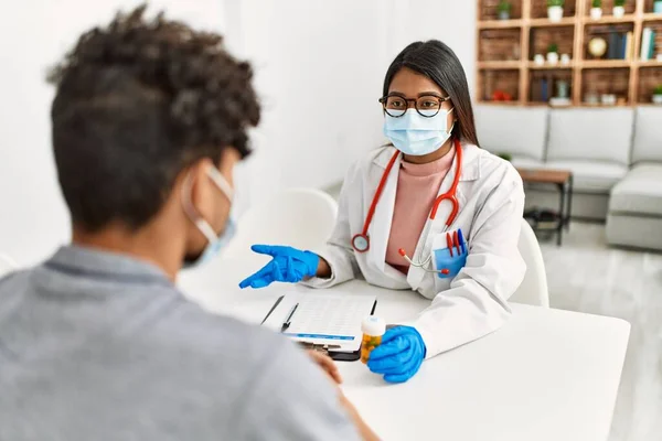 Tıbbi Konsültasyonda Konuşan Genç Latin Doktor Kadın Klinikteki Adama Hap — Stok fotoğraf