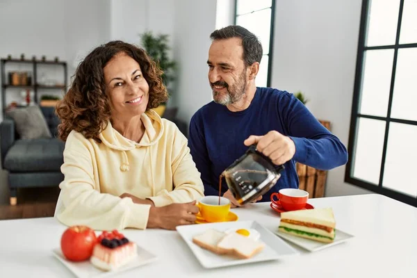 Pareja Hispana Mediana Edad Sonriendo Feliz Sentada Mesa Desayunando Casa —  Fotos de Stock