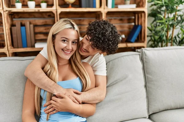 Young Couple Sitting Sofa Hugging Home — Stock Photo, Image