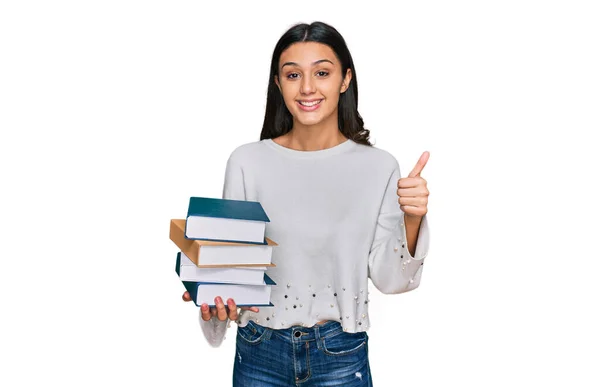 Joven Chica Hispana Sosteniendo Montón Libros Sonriendo Feliz Positivo Pulgar —  Fotos de Stock