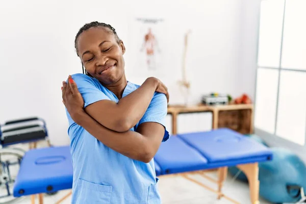 Чорна Жінка Косами Працюють Клініці Відновлення Болю Обіймає Себе Щасливою — стокове фото