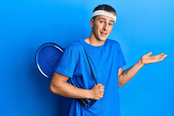 Joven Hombre Caucásico Sosteniendo Bolsa Tenis Celebrando Logro Con Sonrisa —  Fotos de Stock