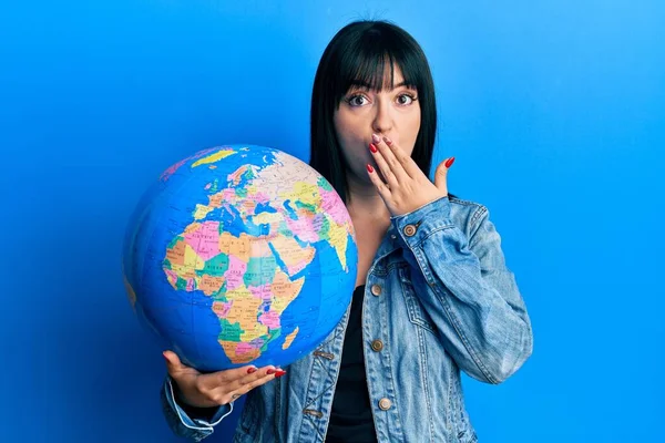 Young Hispanic Woman Holding World Ball Covering Mouth Hand Shocked — Stock Photo, Image