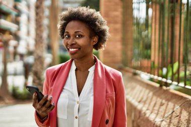 Güzel iş kadını afro saçlı Afro-Amerikan kadın mutlu ve kendinden emin bir şekilde gülümsüyor.