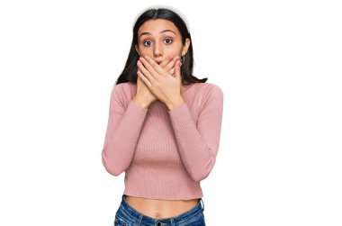 Gündelik kıyafetler giyen genç İspanyol kız yanlışlıkla elleri ile ağzını kapatırken şok oldu. gizli kavram. 