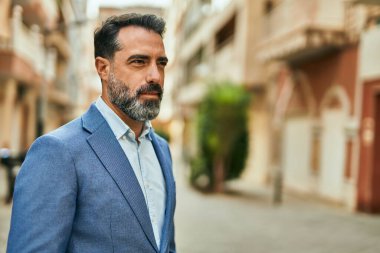 Şehirde duran rahat yüzlü orta yaşlı iş adamı..