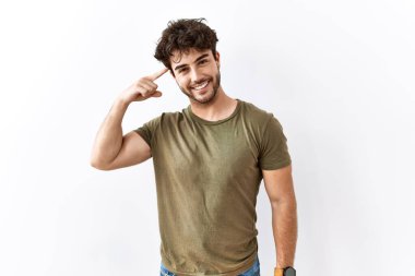 İzole edilmiş beyaz arka planda duran İspanyol adam tek parmakla kafasını işaret ediyor, harika bir fikir ya da düşünce, iyi bir hafıza. 