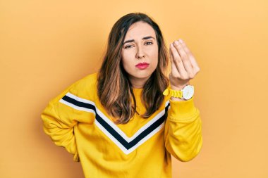 Gündelik kıyafetler giyen genç İspanyol kız İtalyan jesti yapıyor, elleri ve parmakları ile kendinden emin ifade ediyor. 