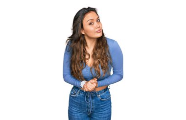 Elleri çapraz parmaklarla gülümseyen rahat ve neşeli, günlük kıyafetler giyen genç İspanyol kız. Başarı ve iyimserlik 