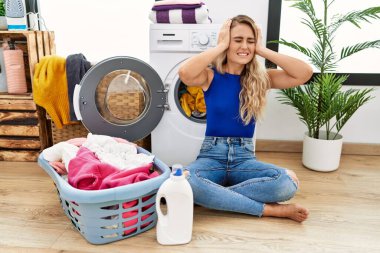 Genç, güzel bir kadın hasır sepetin yanında oturup acı ve migrenden dolayı çaresiz ve stresli bir şekilde çamaşır yıkıyor. Eller başının üstünde.. 