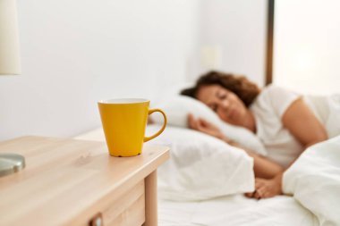 Orta yaşlı İspanyol kadın yatak odasında yatakta uyuyor.