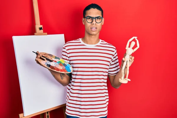 Young African American Guy Holding Painter Palette Art Manikin Shock — Stock Photo, Image