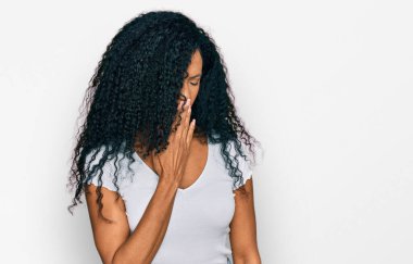 Orta yaşlı Afro-Amerikalı kadın, günlük beyaz tişört giymekten sıkılmış, ağzıyla esnemekten sıkılmış. Huzursuz ve uykulu.. 