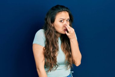 Günlük kıyafetler giyen genç İspanyol kız pis ve iğrenç bir koku alıyor. Nefesini burnunda tutuyor. Kötü kokuyor. 