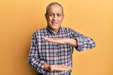 Gri saçlı, sıradan tişörtlü, elleri büyük ve büyük beden işareti gösteren yakışıklı bir son sınıf öğrencisiydi. Kameraya bakıp gülümsüyor. ölçüm kavramı. 