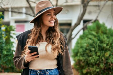 Şehirde akıllı telefon kullanan genç İspanyol turist kadın..