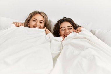 Genç, güzel bir çift yatakta uzanıyor ve evde battaniyeyle örtüyor..