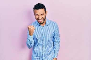 Sakallı, sıradan mavi tişörtlü, sinirli, kızgın, sinirli ve öfkeliyken öfkeyle bağıran İspanyol bir adam. öfke ve agresif konsept. 