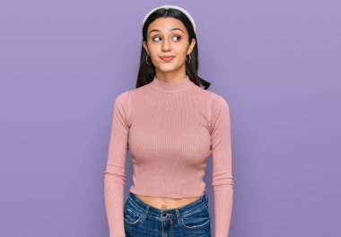 Gündelik kıyafetler giyen genç İspanyol kız gülümseyip yan tarafa bakıyor ve düşünüyor.. 