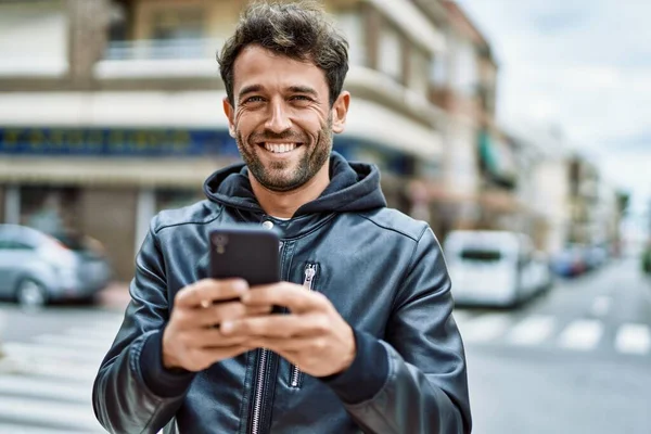 Hezký Hispánský Muž Vousy Usměvavý Šťastný Venku Pomocí Smartphone — Stock fotografie