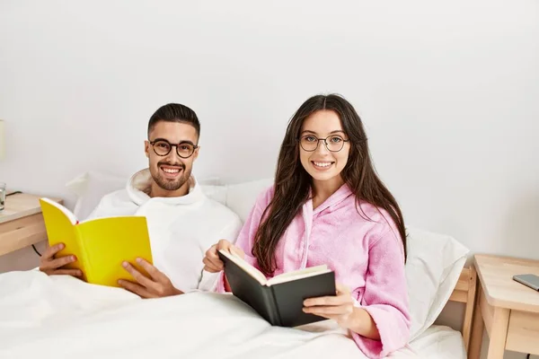 Jovem Casal Hispânico Lendo Livro Deitado Cama Casa — Fotografia de Stock