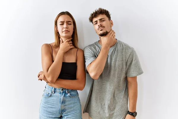 Jovem Casal Bonito Juntos Sobre Fundo Isolado Tocando Pescoço Doloroso — Fotografia de Stock