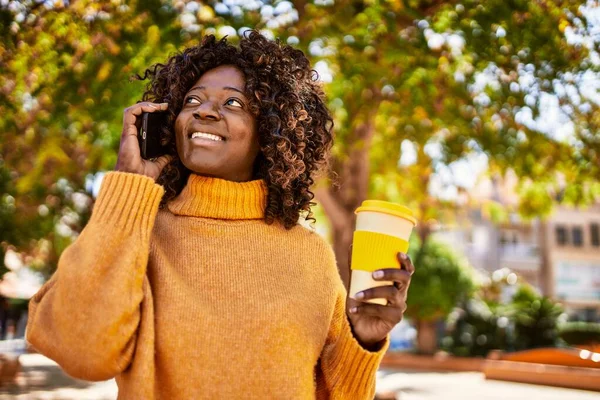 非洲裔美国妇女在公园用智能手机喝咖啡 — 图库照片
