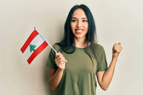 Jovem Hispânica Segurando Bandeira Lebanon Apontando Polegar Para Lado Sorrindo — Fotografia de Stock