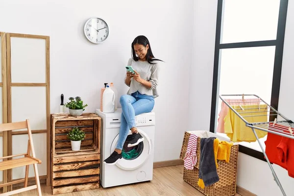 Jovem Mulher Latina Usando Smartphone Espera Máquina Lavar Roupa Lavanderia — Fotografia de Stock