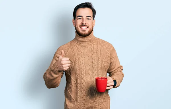 Młody Hiszpan Trzyma Kawę Uśmiechniętą Szczęśliwie Pozytywnie Kciuk Góry Robi — Zdjęcie stockowe