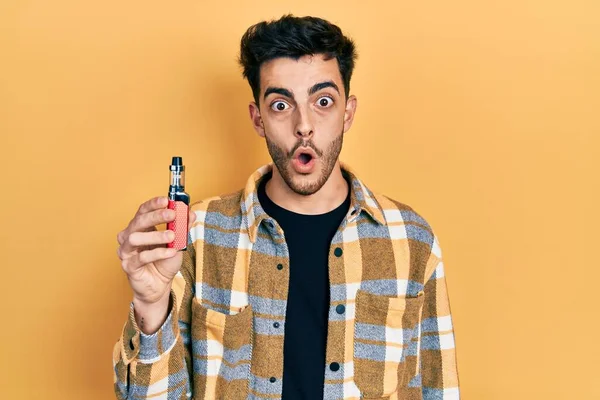 Jonge Spaanse Man Houdt Elektronische Sigaret Bang Verbaasd Met Open — Stockfoto