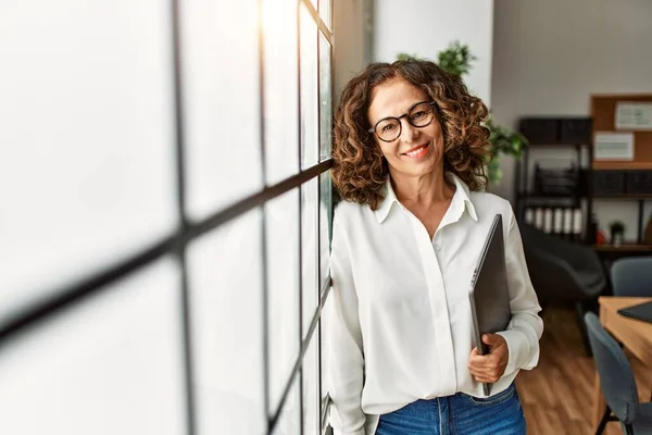 Mujer Hispana Mediana Edad Sonriendo Confiada Sosteniendo Portapapeles Oficina —  Fotos de Stock