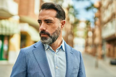 Şehirde duran rahat yüzlü orta yaşlı iş adamı..