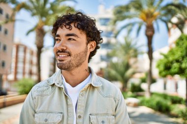 Yakışıklı, sakallı, güneşli bir günde mutlu bir şekilde gülümseyen bir İspanyol.