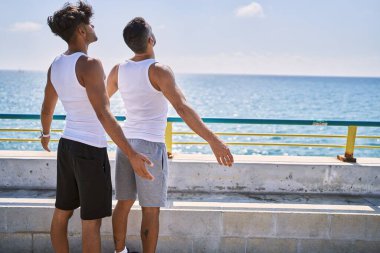 Genç İspanyol çift kumsalda kolları açık nefes alıyor..