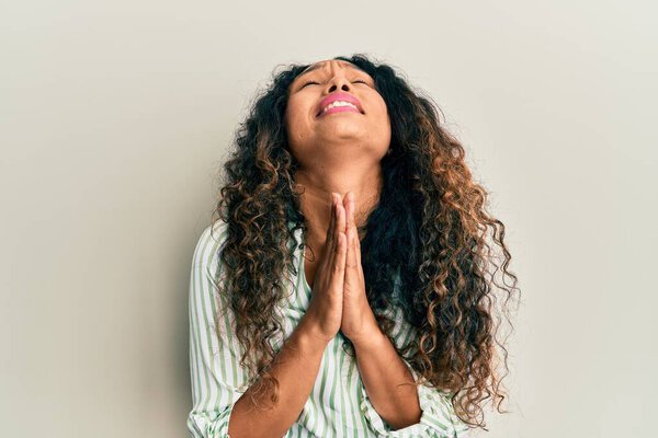 Young latin woman wearing casual clothes begging and praying with hands together with hope expression on face very emotional and worried. begging. 